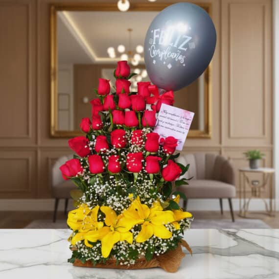 Arreglo floral exótico Gamma con rosas rojas, lirios amarillos y un globo de 'Feliz Cumpleaños' sobre una mesa de mármol en u