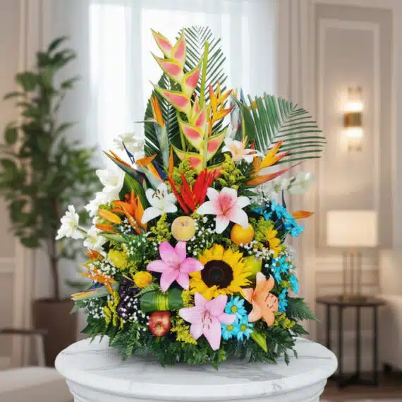 Arreglo Floral con Frutas Tentación: Exotismo y Elegancia para tu Hogar Arreglo floral exótico y vibrante con frutas, lirios, girasoles y aves del paraíso sobre una base de mármol en un entorno ele