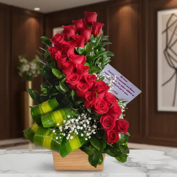 Arreglo Floral con Rosas Espiral: Elegancia y Pasión en Cada Pétalo Arreglo floral premium con rosas rojas en espiral, follaje verde y flores blancas, sobre mármol en un entorno elegante.