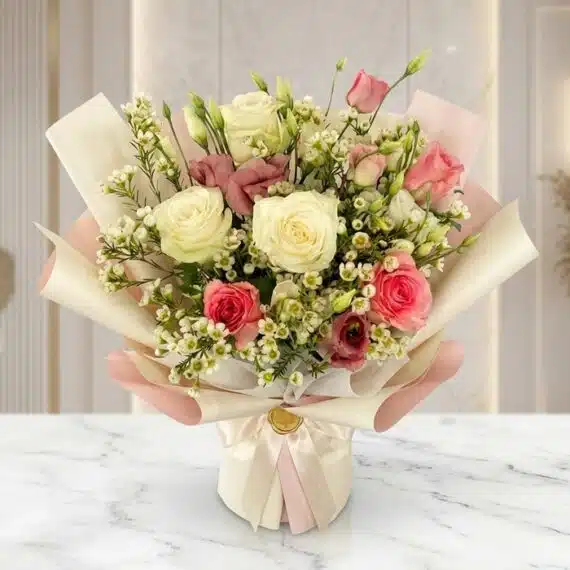 Bouquet Floral SUSANA con rosas blancas y rosadas, astromelias y follaje verde, envuelto en papel coreano rosa y crema, sobre