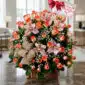 Canasta de rosas naranjas y orquídeas rosadas en un arreglo floral elegante con un lazo de arpillera y una tarjeta de 'Happy