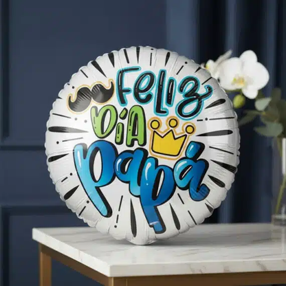 Globo Metalizado Feliz Día Papá: Regalo Ideal para Celebrar Globo metalizado blanco con la frase 'Feliz Día Papá' en colores vibrantes, bigote y corona, sobre una mesa de mármol con orq