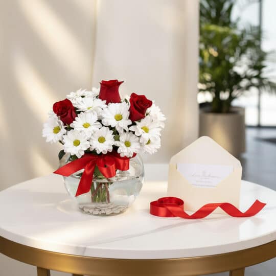 Jarron Floral Antonietta con rosas rojas y margaritas blancas, lazo rojo, tarjeta de regalo en sobre y cinta satinada sobre m