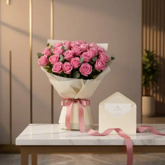 Ramo de 44 rosas rosadas Viviana, envuelto en papel crema con cinta satinada rosa, sobre mesa de mármol con tarjeta de regalo